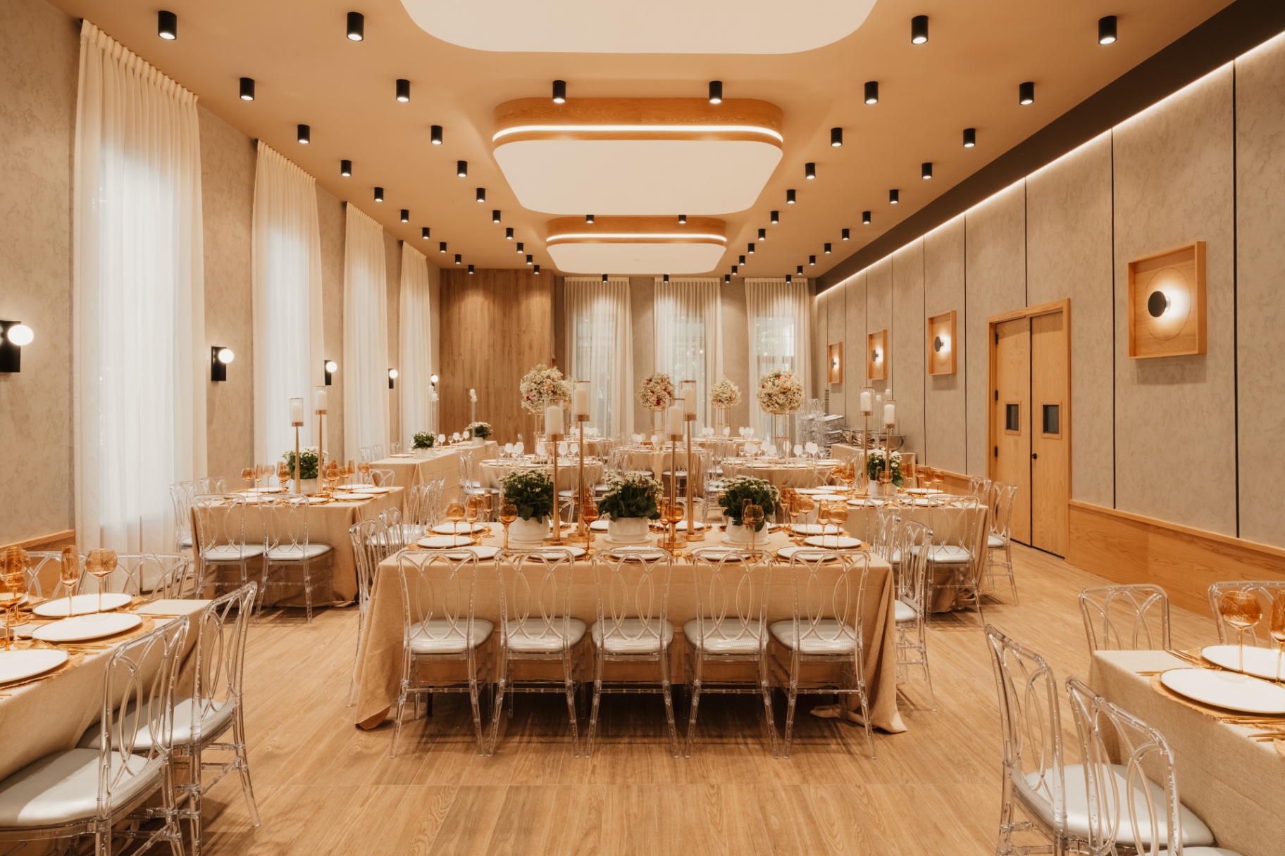 Event room set with a long banquet table, candles and floral centerpieces