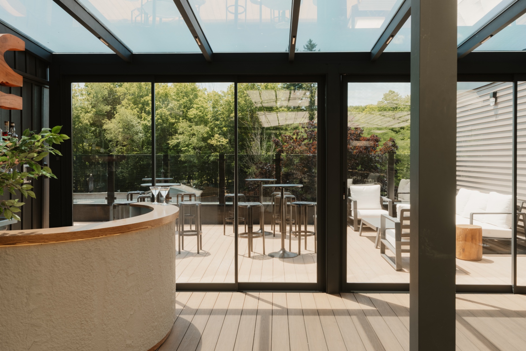 Floor-to-ceiling glass doors opening from the lounge onto the outdoor deck