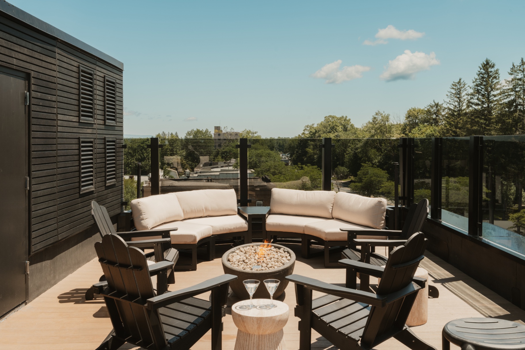 Upper outdoor lounge with cushioned sofas, Adirondack chairs and a firepit