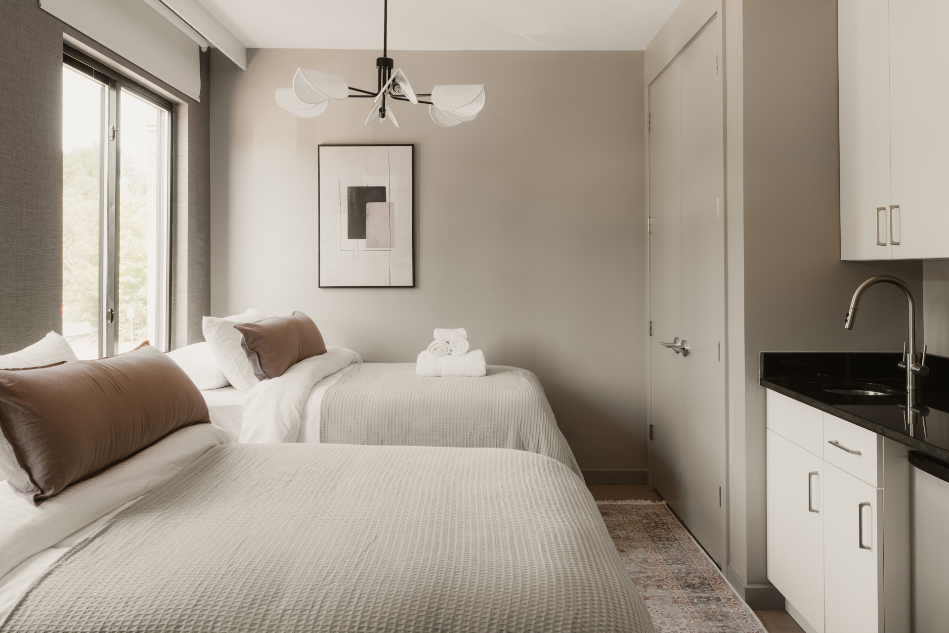Guest room with two beds, artwork and a private kitchenette