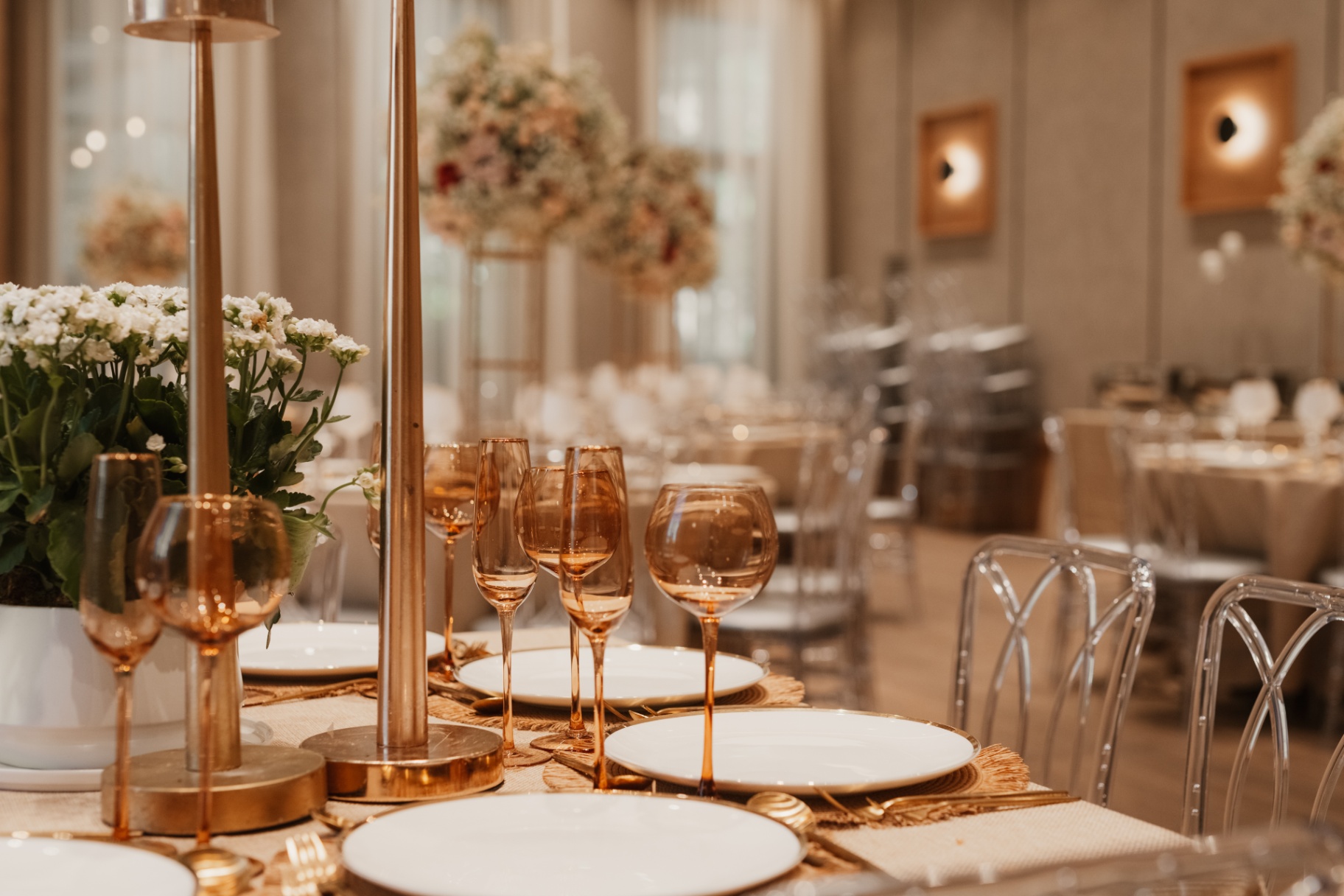 Tall floral centerpiece above a gold and amber place setting