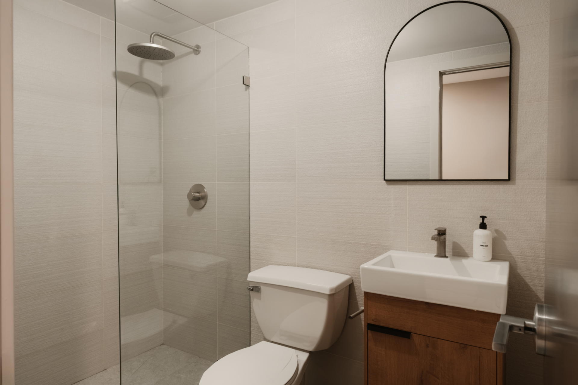 Bathroom with a walk-in glass shower and wood vanity