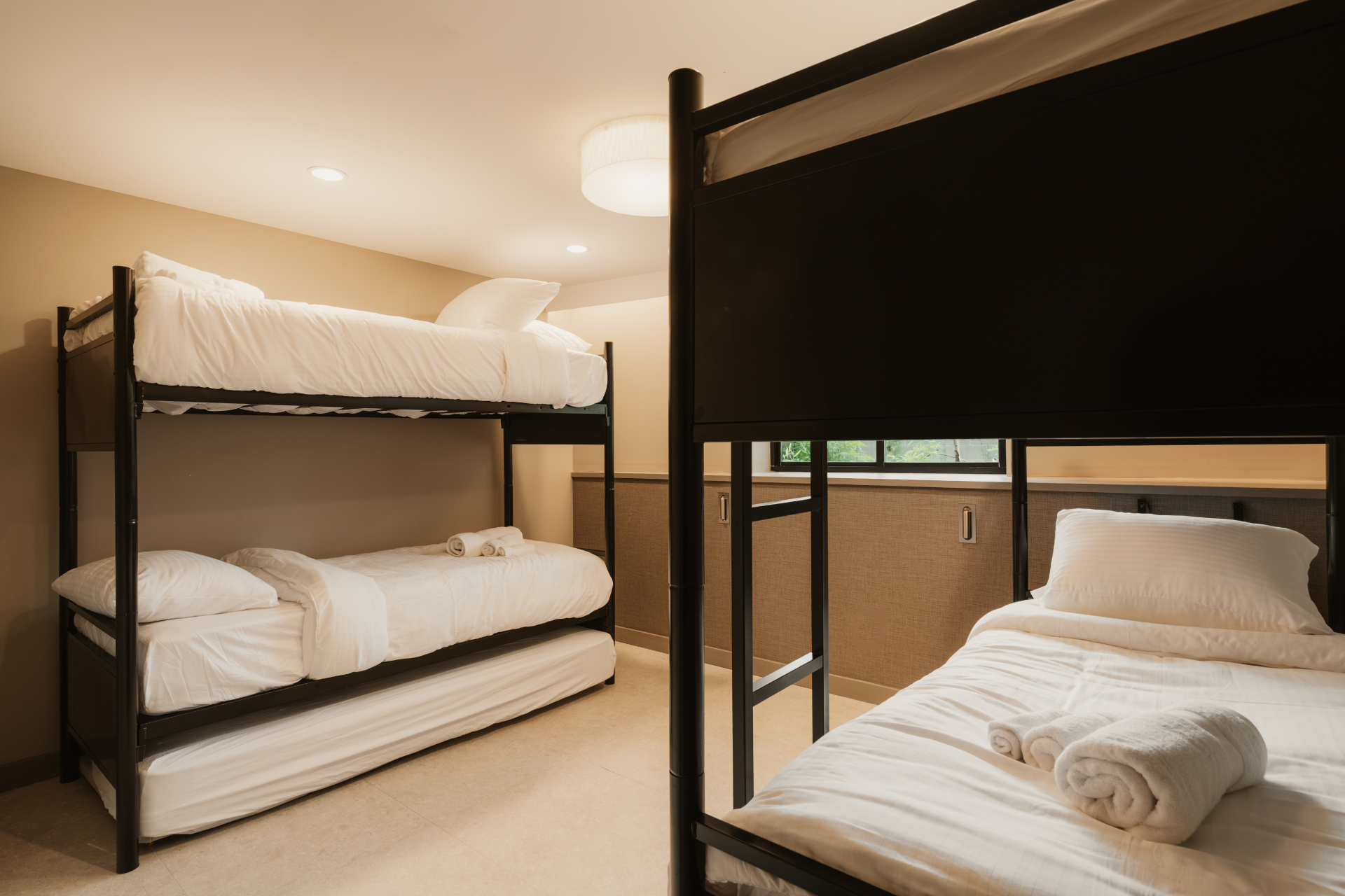 Bunk beds with folded towels in a warm-toned guest room