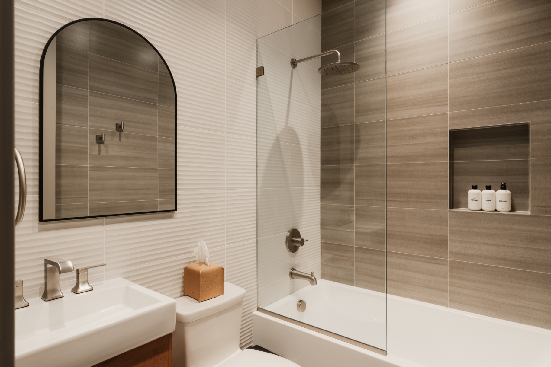 Ensuite bathroom with a tub, rainfall shower and stone-look tile
