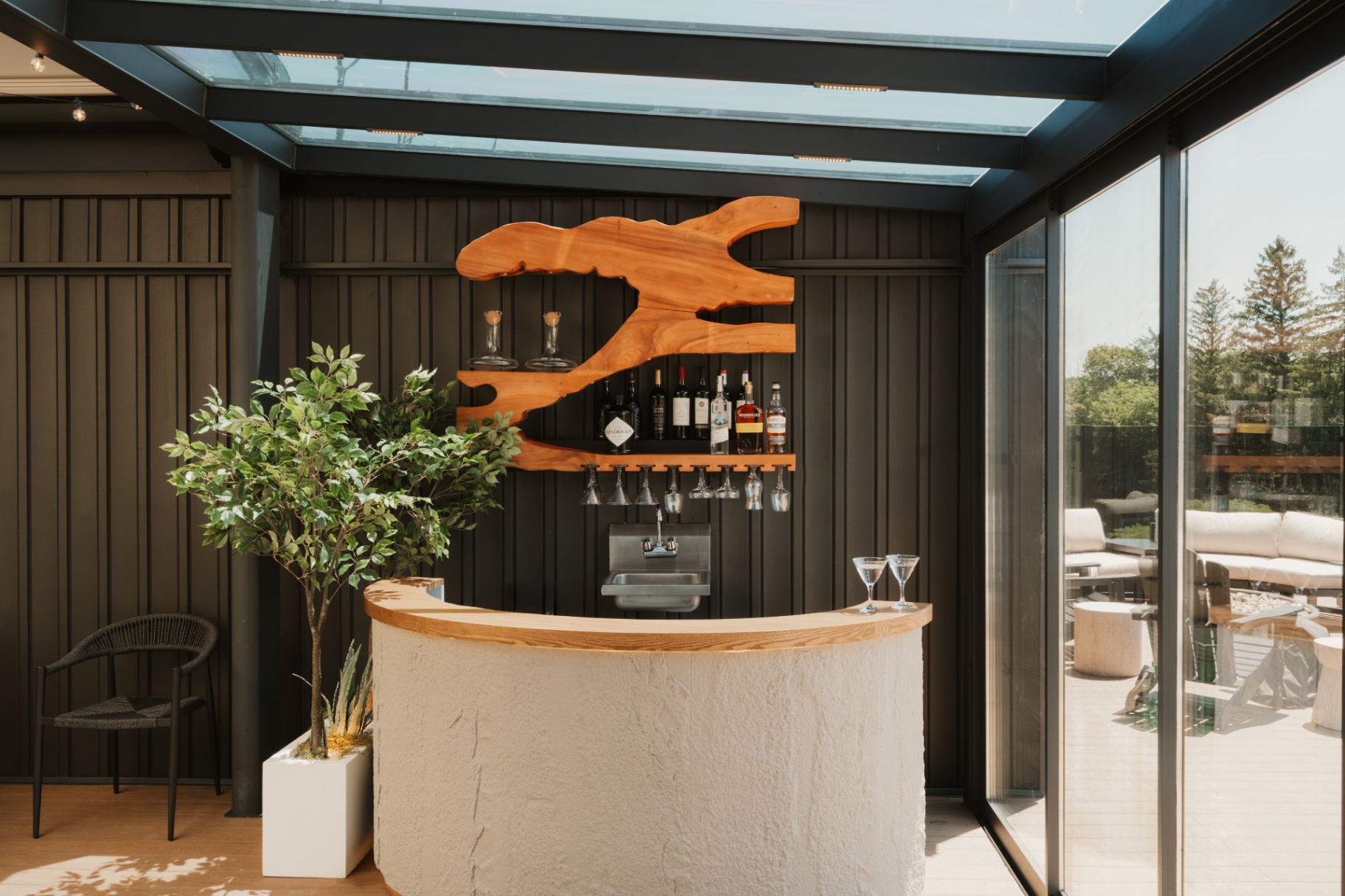 Curved bar counter with a backlit wine display in the terrace lounge