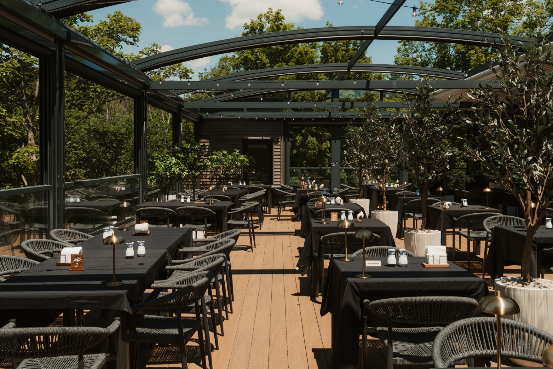 Long communal table inside the glass-enclosed terrace at The Belvedere Suites