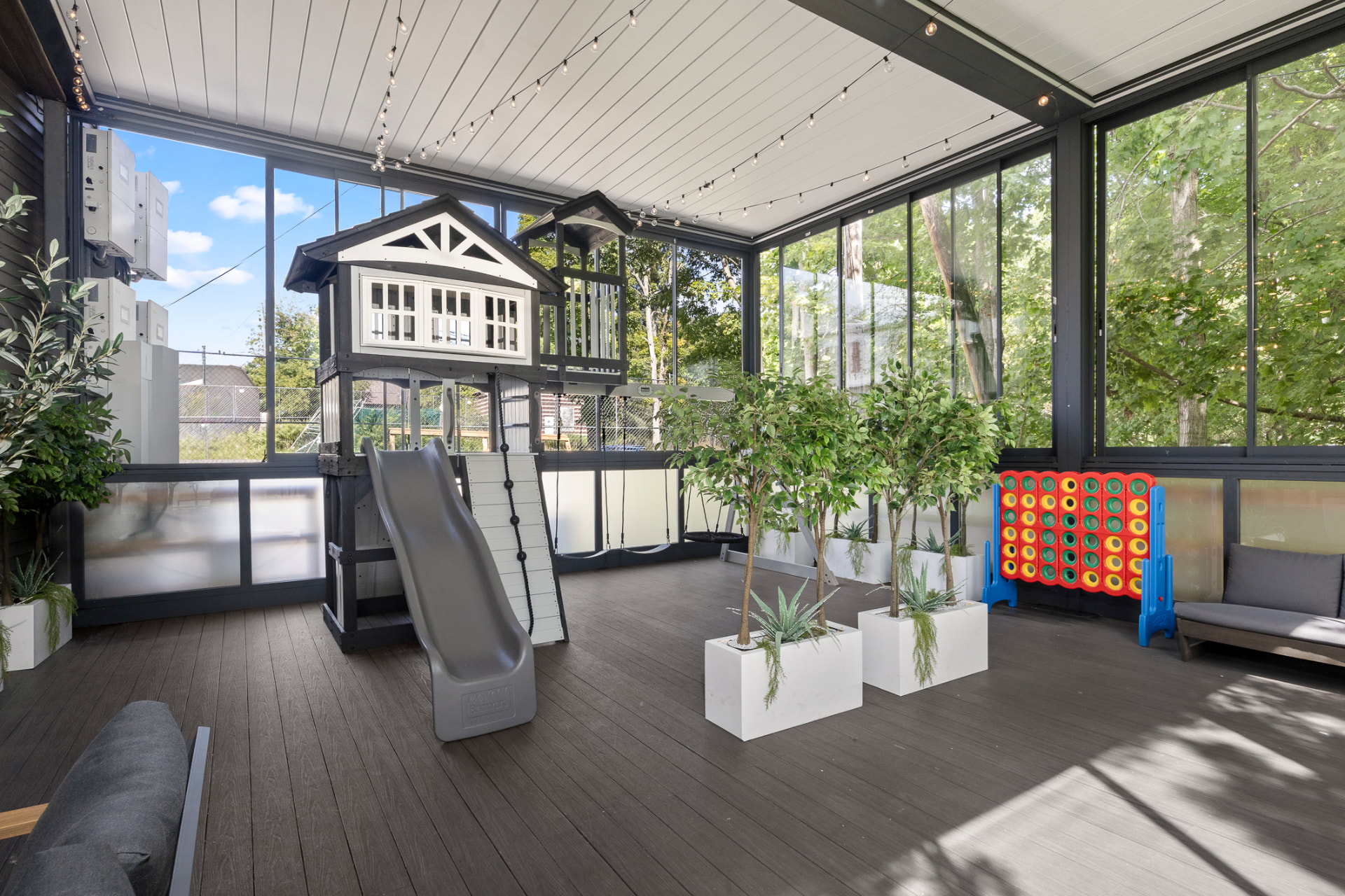 Children's playhouse with slide and swings inside the glass-enclosed terrace