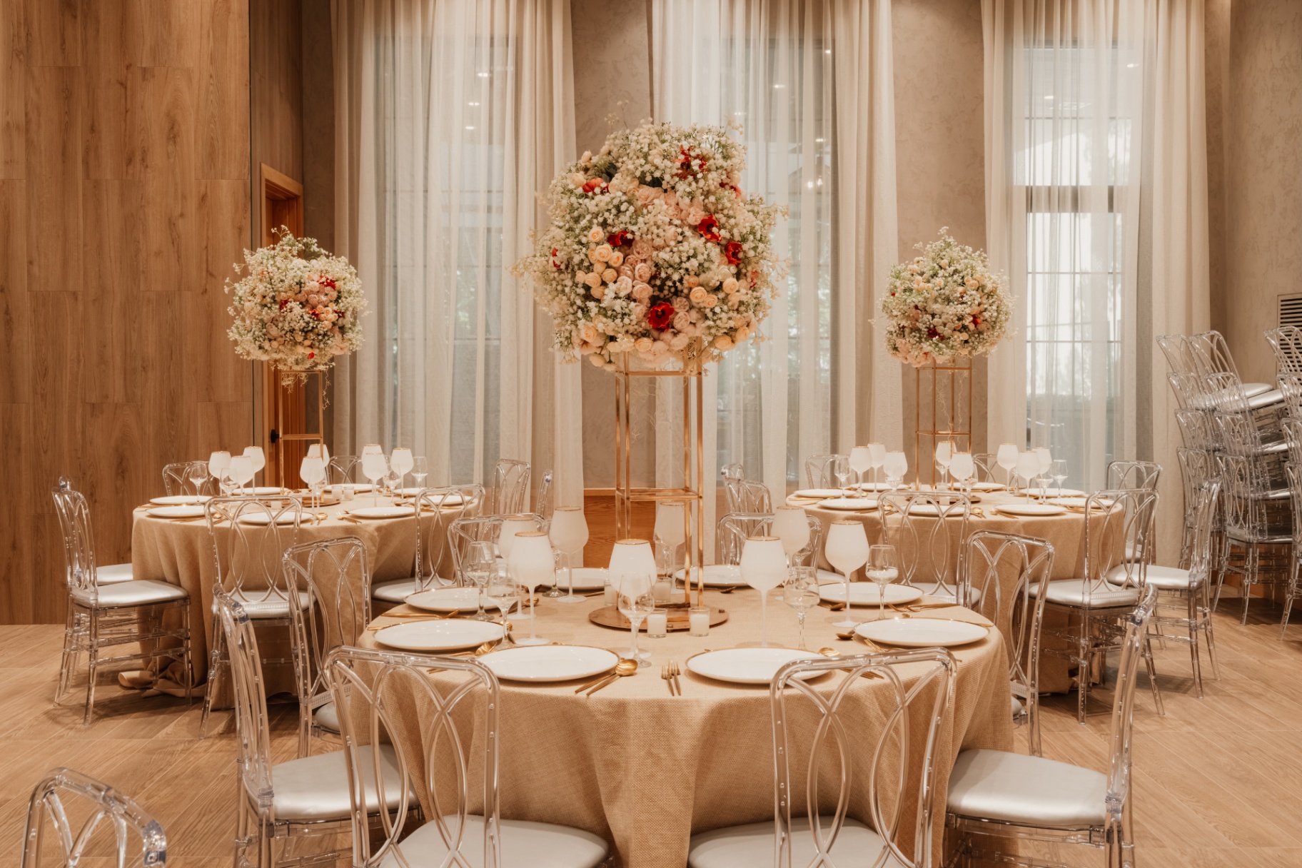 Round tables with tall blush floral centerpieces set for a simcha