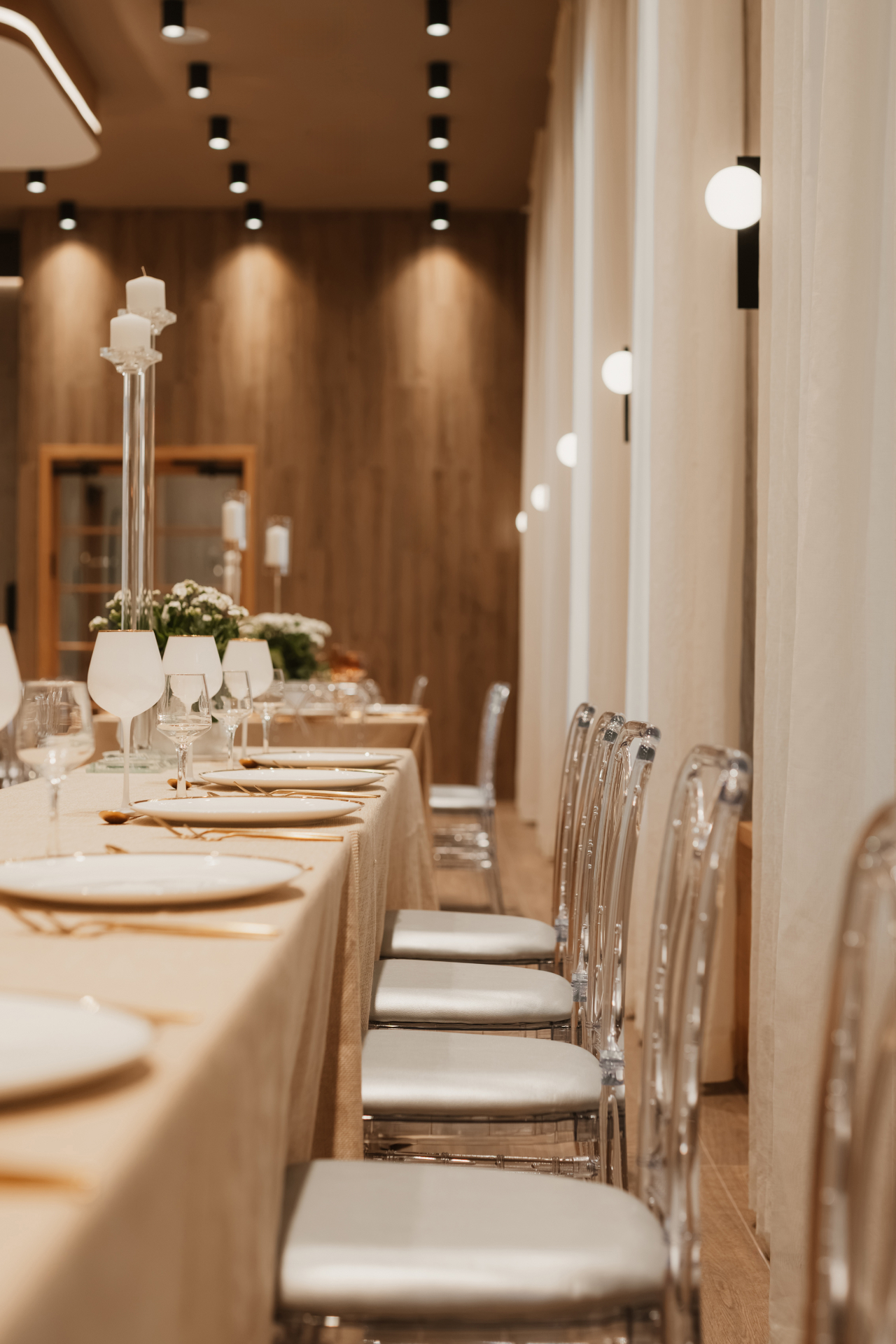 Close view of a banquet table dressed in champagne linens and clear chairs