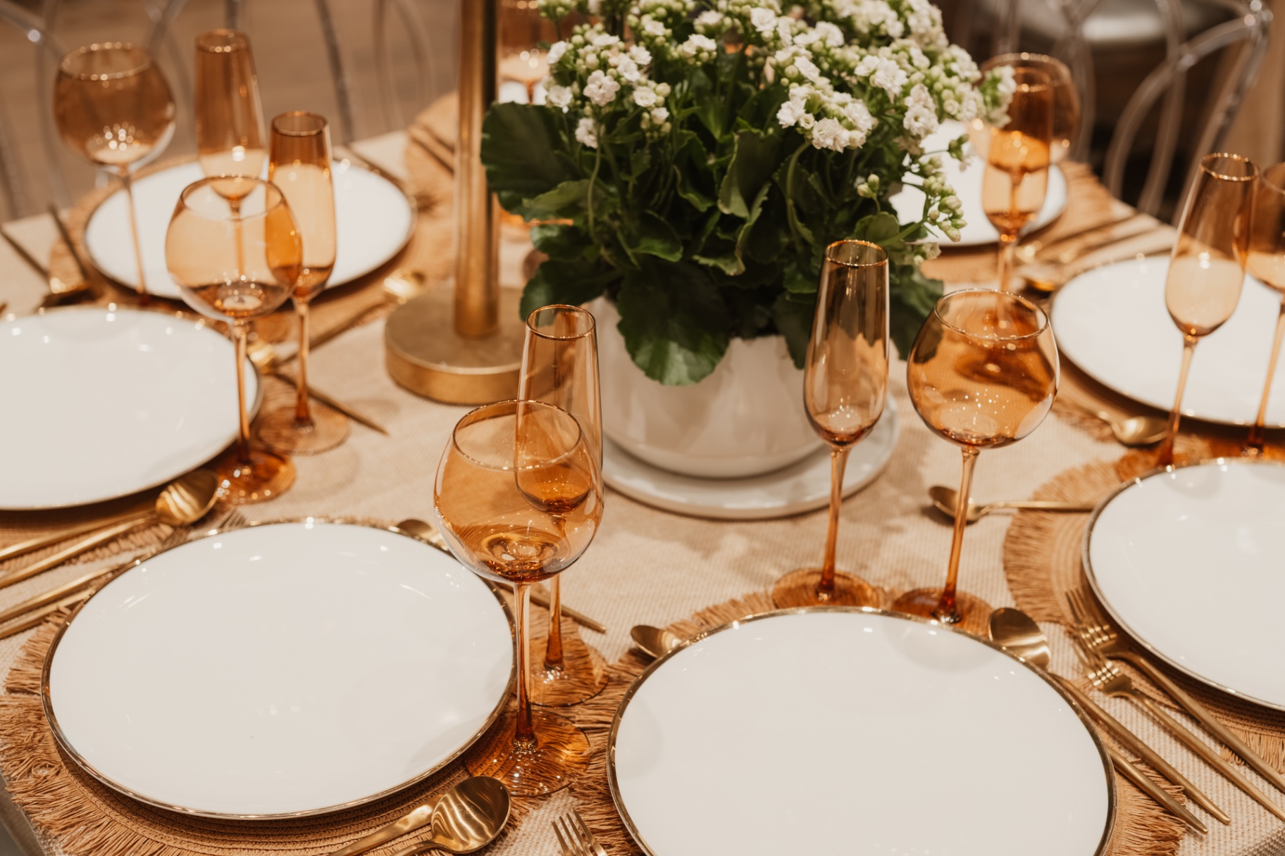 Close-up of a place setting with white flowers and amber goblets