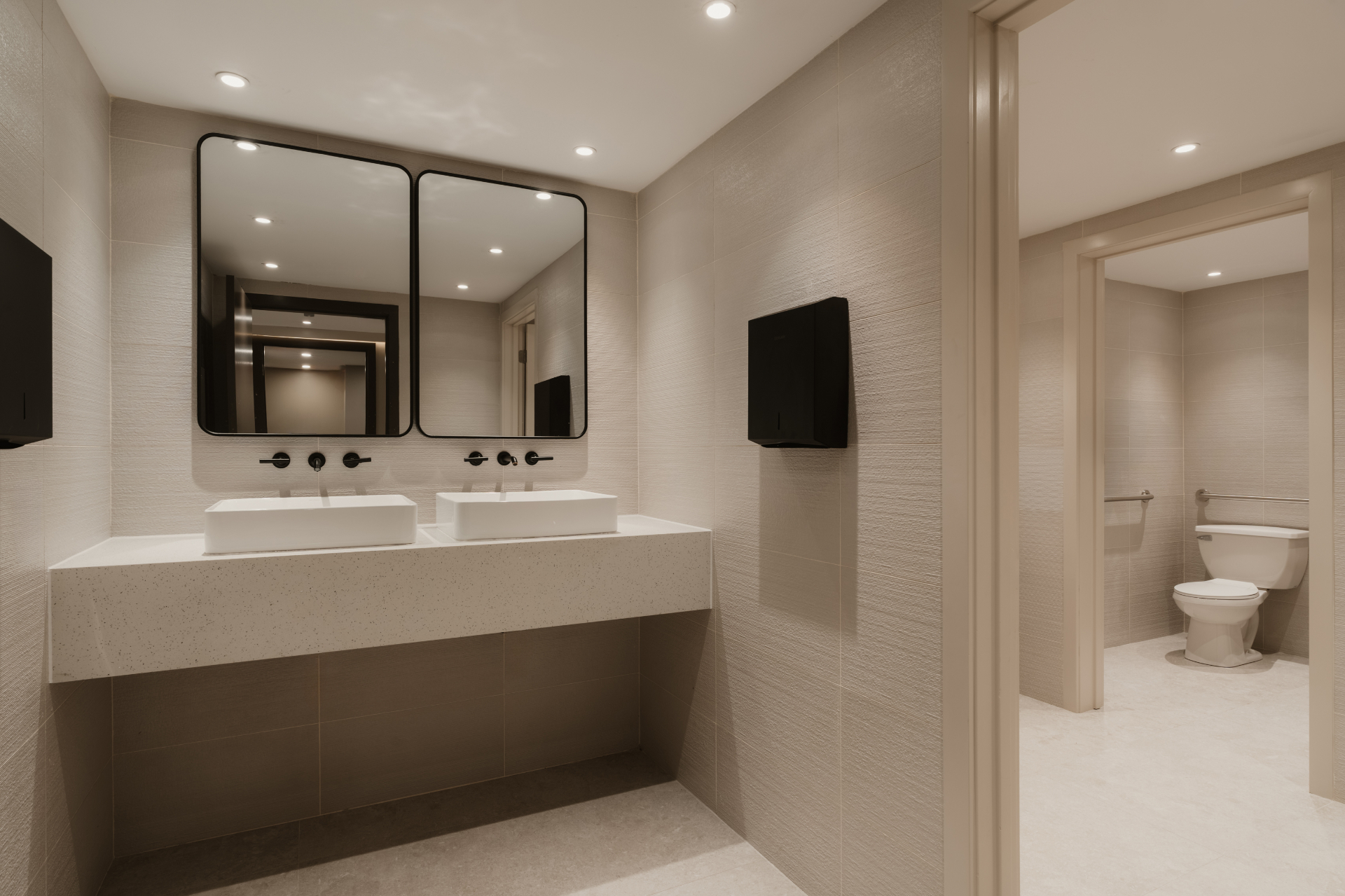 Shared bathroom with a long double vanity and separate toilet room