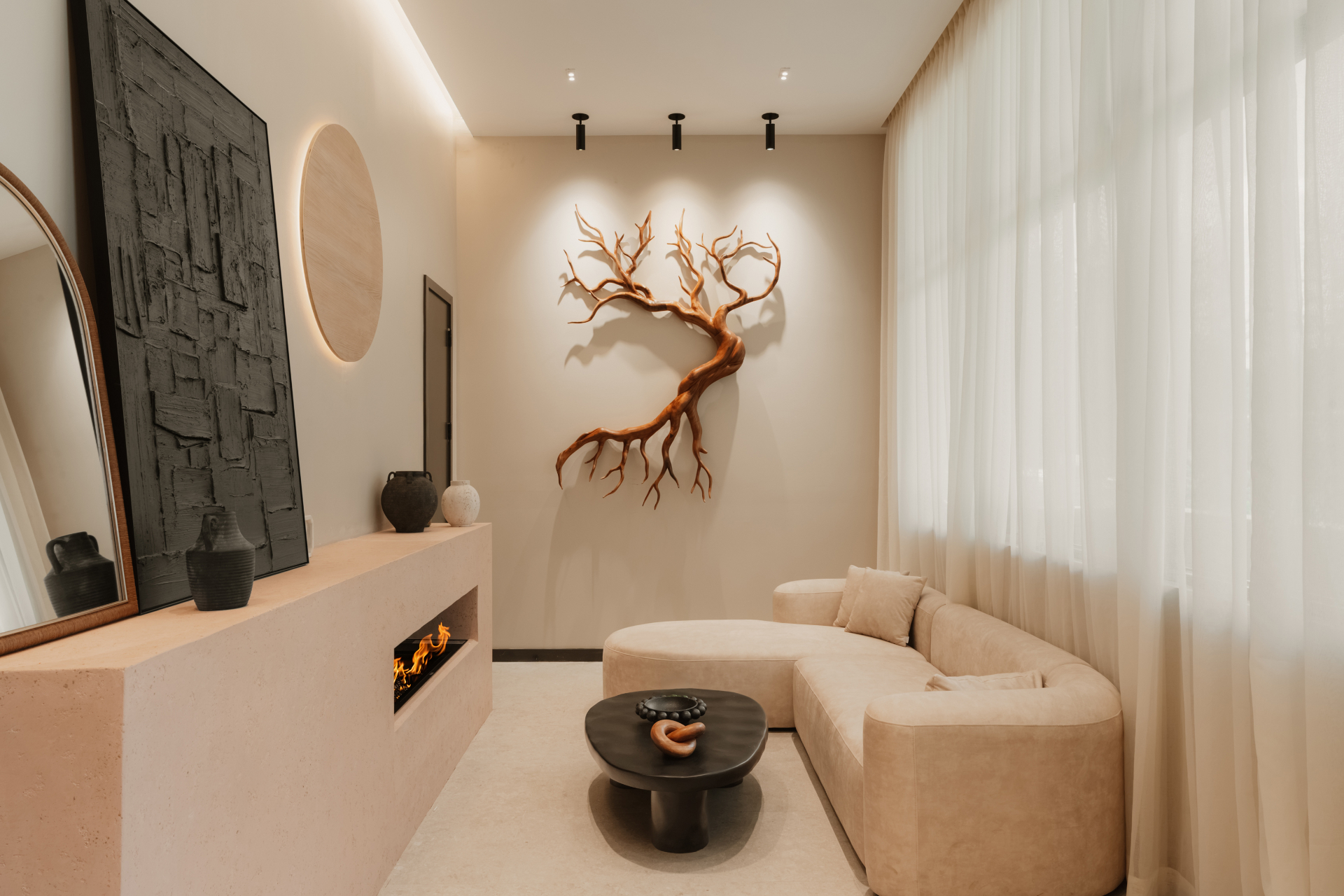 Elegant lounge with a linear fireplace, sculptural wall art and a curved sofa